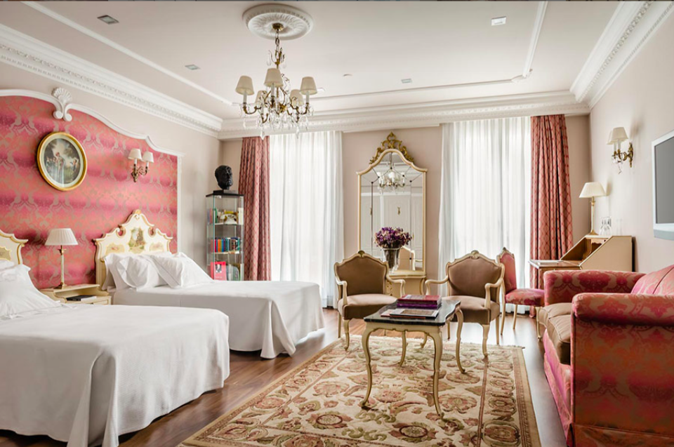 Pamplona Running of the Bulls 2026: Complete Travel Guide & Cultural Context photo | Cosmopolitours Hemingway Suite at Hotel La Perla in Pamplona, featuring classic European decor, twin beds, antique furnishings, and natural light, ideal luxury accommodation for San Fermín festival guests.