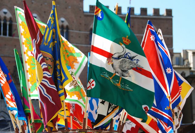 Palio di Siena 2026 Colorful Contrada flags of Siena the Palio di Siena festival, representing the city’s 17 historic neighborhoods.